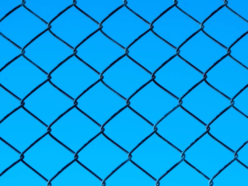 chain link fence with a blue sky at the back